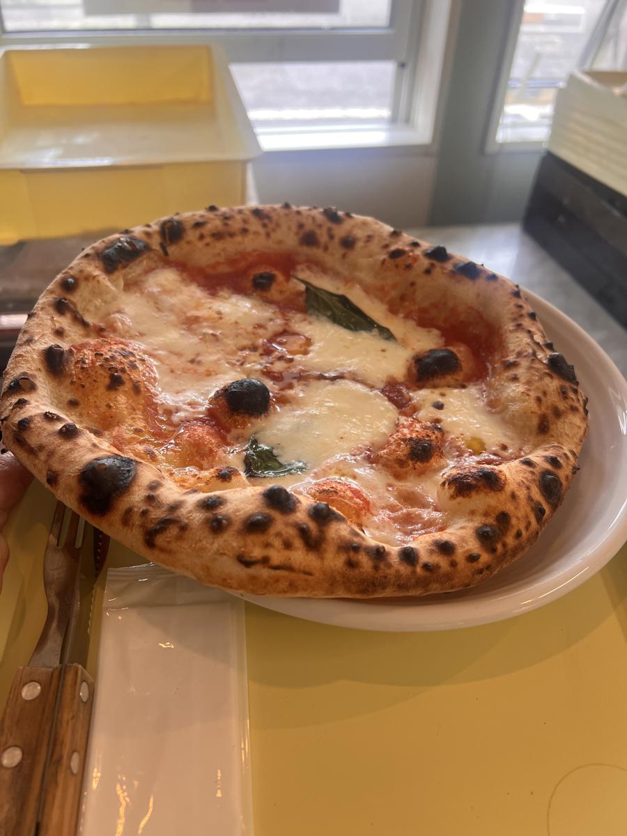 手に持った、窯で焼いたマルゲリータ